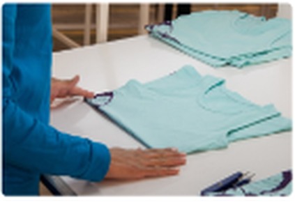 Illustrative garment inspection and folded knitwear on a table